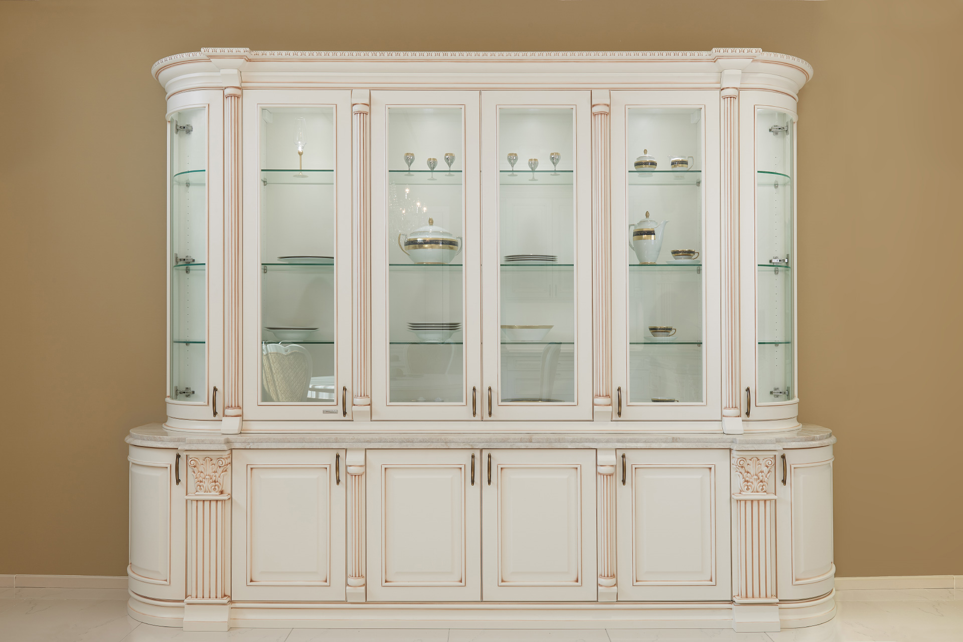 Tall cabinets with glass showcases and round doors representing the highest art in furniture Rustic kitchen by Hanák model Royal in white matt lacquer with bronze patina